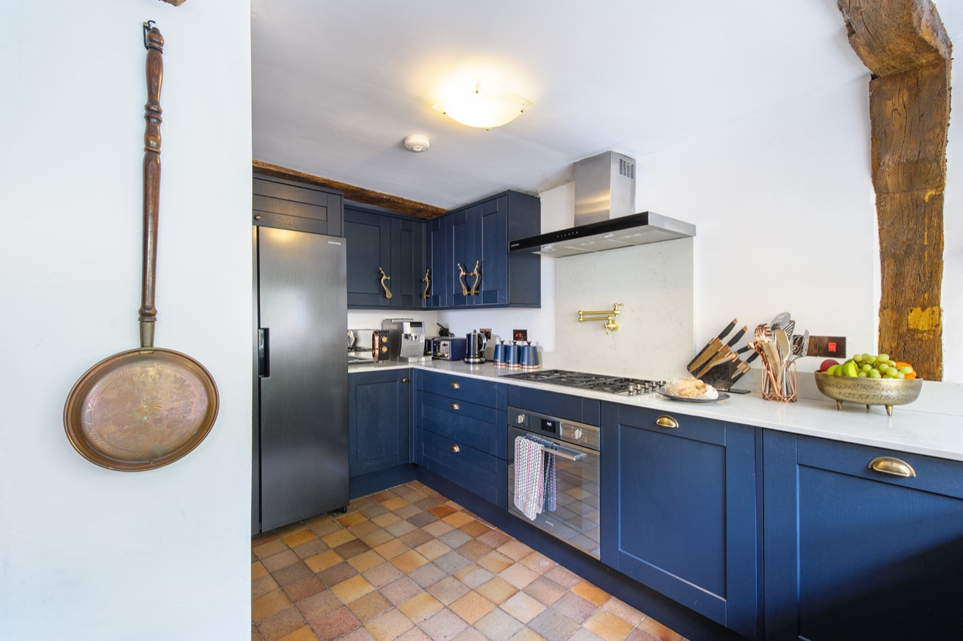 A navy shaker kitchen with brass handles in a managed property